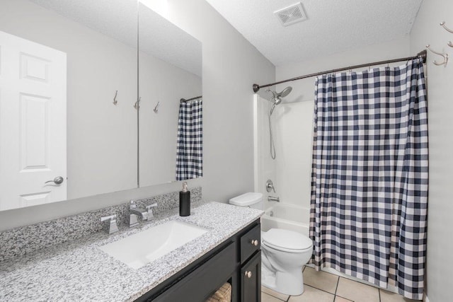 full bathroom featuring vanity, visible vents, tile patterned flooring, a textured ceiling, and toilet