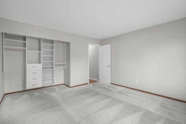 unfurnished bedroom with a closet, baseboards, and carpet floors