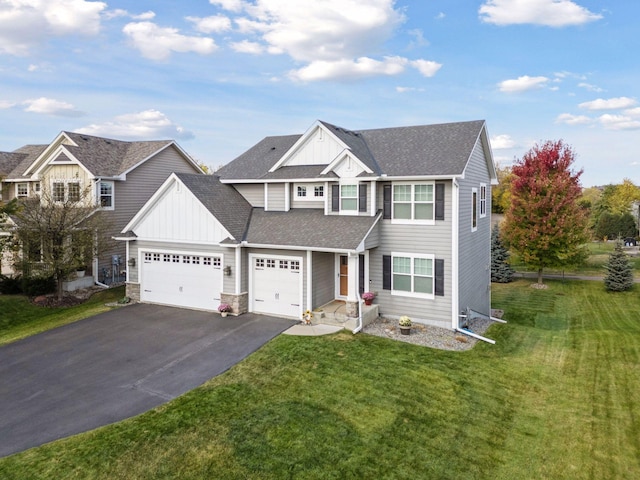 view of front facade featuring a garage, board and batten siding, a front yard, and aphalt driveway