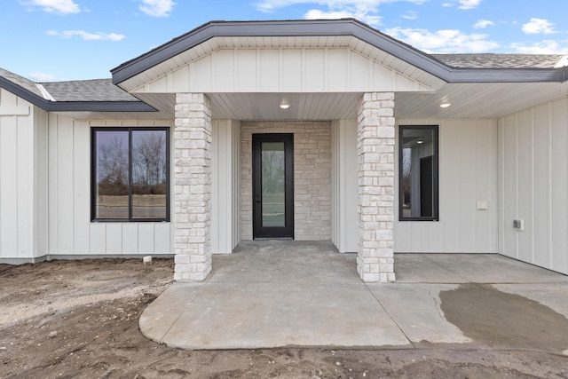 doorway to property featuring a shingled roof