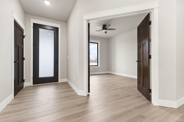 entryway featuring baseboards, ceiling fan, and light wood finished floors