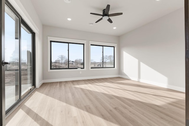 unfurnished room with light wood finished floors, recessed lighting, a healthy amount of sunlight, and baseboards