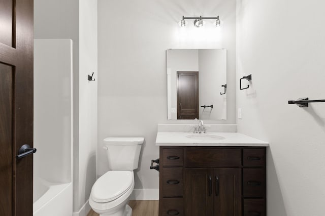 full bath with toilet, vanity, baseboards, and wood finished floors