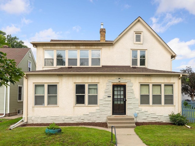 view of front of house featuring stucco siding, a chimney, a front lawn, and fence