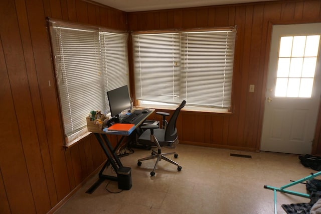 office area with visible vents and wooden walls