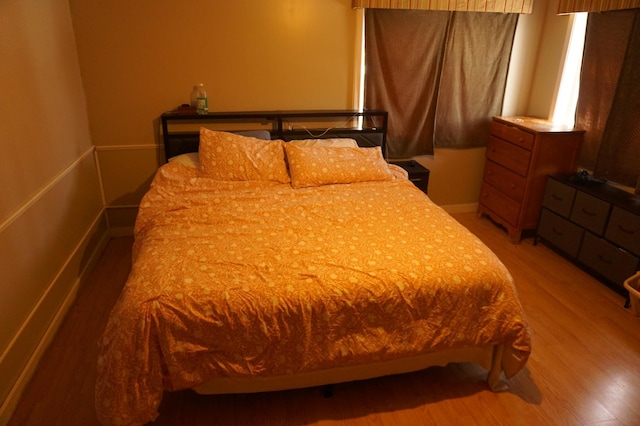 bedroom with baseboards and light wood finished floors