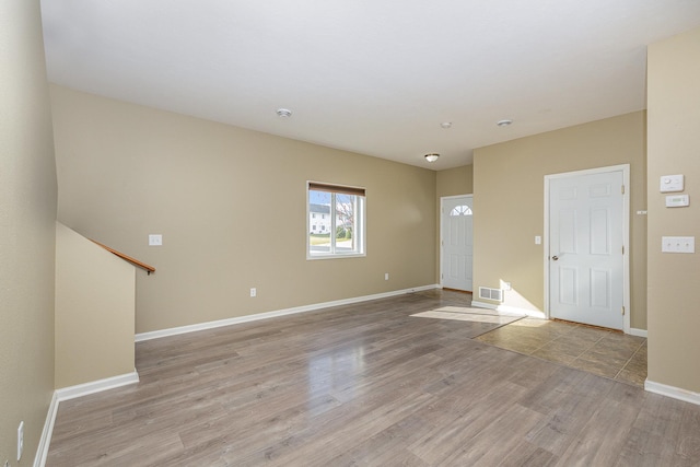 interior space with light wood-type flooring, baseboards, and visible vents