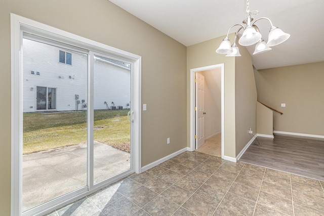 unfurnished room with an inviting chandelier, baseboards, and tile patterned floors