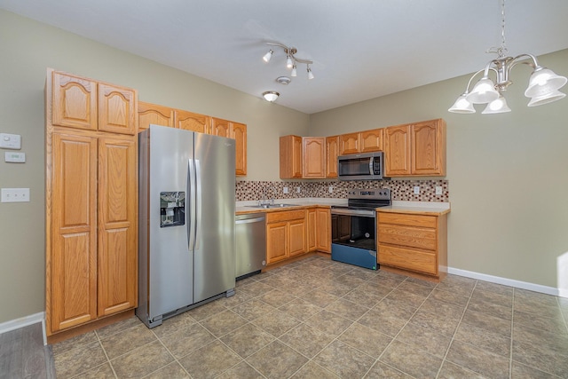 kitchen with a sink, decorative backsplash, appliances with stainless steel finishes, and light countertops