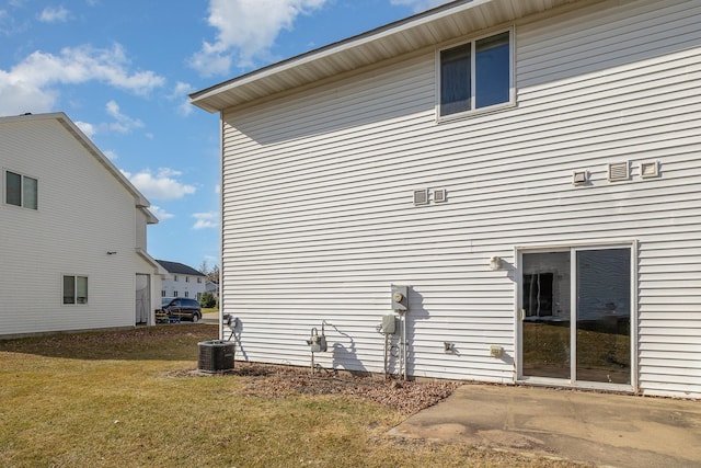 view of side of property featuring a yard and cooling unit