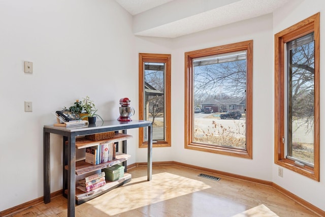 interior space featuring visible vents, baseboards, and wood finished floors