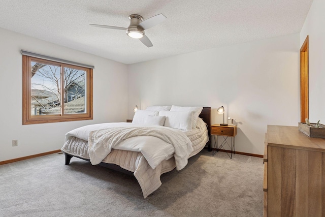 bedroom featuring baseboards, light colored carpet, and a textured ceiling