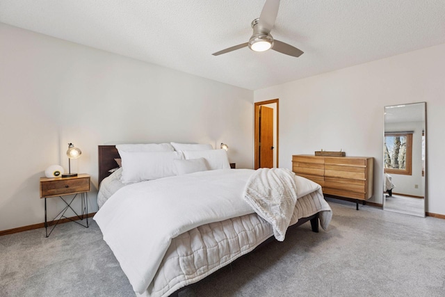 carpeted bedroom featuring a ceiling fan, baseboards, and a textured ceiling