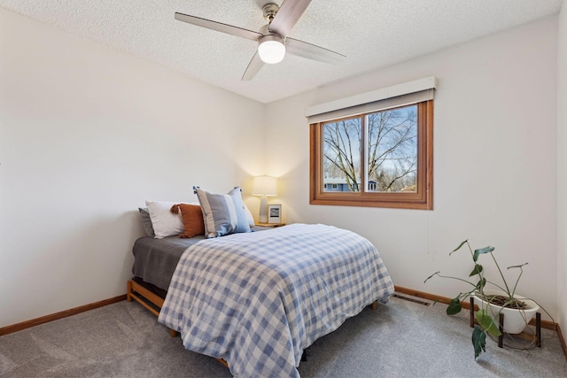 bedroom featuring carpet, baseboards, and a textured ceiling