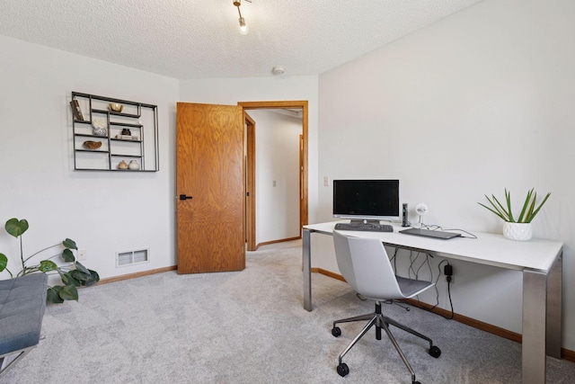 office area featuring carpet flooring, baseboards, visible vents, and a textured ceiling