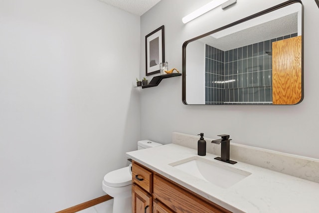 bathroom featuring vanity, toilet, and a textured ceiling