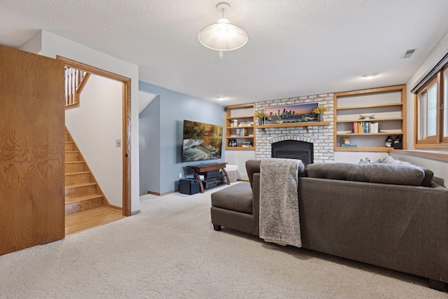 living room with visible vents, stairway, carpet floors, a fireplace, and a textured ceiling