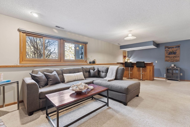 living area featuring light carpet, visible vents, a textured ceiling, and baseboards