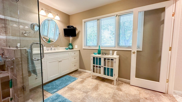 bathroom featuring a stall shower, vanity, and baseboards