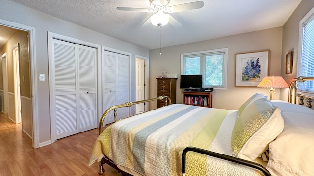 bedroom featuring ceiling fan, wood finished floors, and a textured ceiling