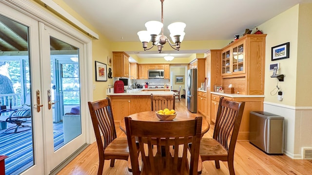 dining room featuring a notable chandelier, visible vents, french doors, and light wood-style floors