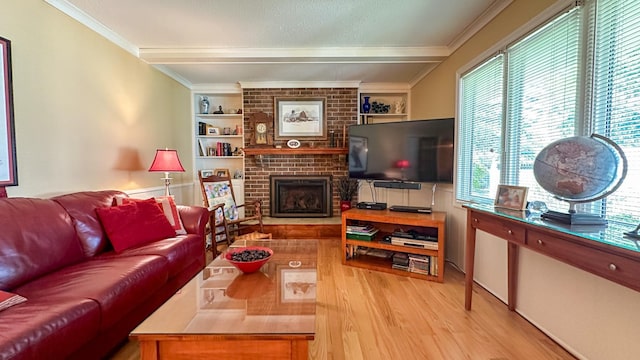 living room featuring beam ceiling, ornamental molding, built in features, wood finished floors, and a fireplace