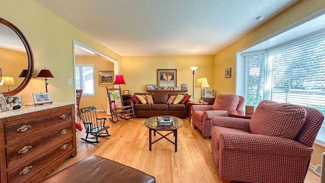 living area with light wood-style flooring and a textured ceiling