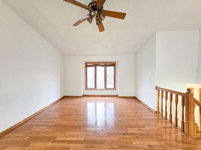 empty room with a ceiling fan, baseboards, and light wood-type flooring