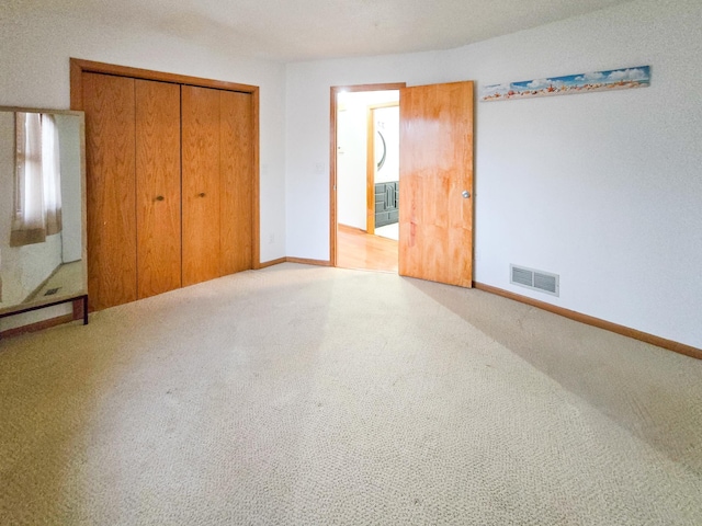 unfurnished bedroom featuring a closet, visible vents, baseboards, and carpet floors