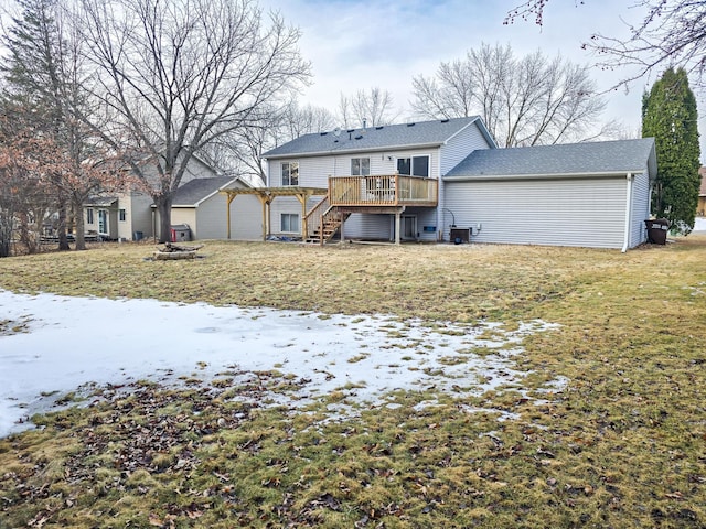 rear view of house featuring a fire pit, stairway, a wooden deck, a lawn, and an outdoor structure