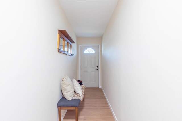 doorway to outside with light wood-style flooring and baseboards