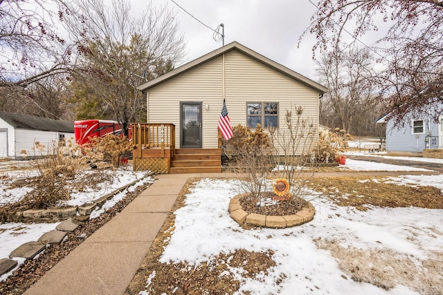 snow covered rear of property featuring a wooden deck