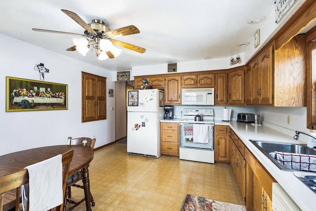 kitchen featuring white appliances, light floors, a sink, light countertops, and brown cabinets