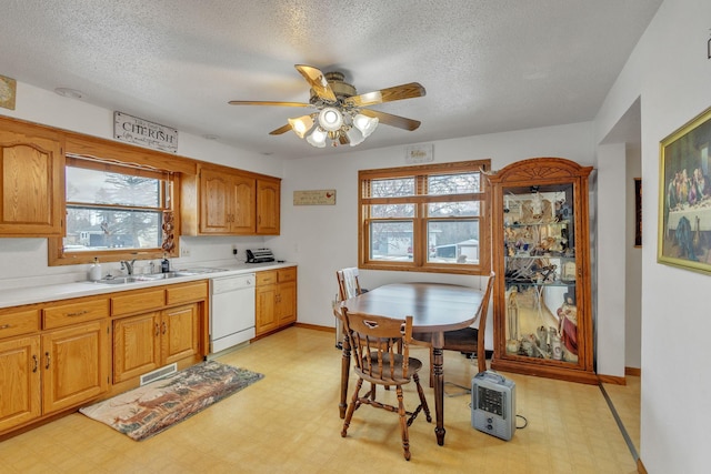 kitchen with a sink, light floors, light countertops, and white dishwasher