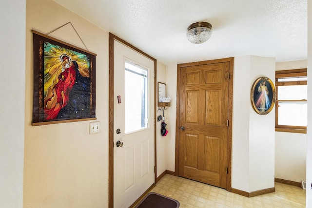 foyer with light floors, baseboards, and a wealth of natural light