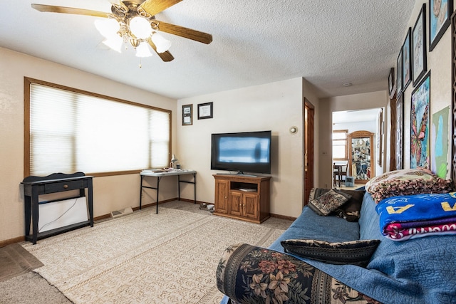 living room featuring a wealth of natural light, a textured ceiling, and a ceiling fan