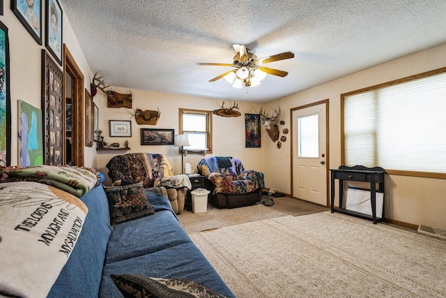 living area featuring a textured ceiling, ceiling fan, and carpet floors