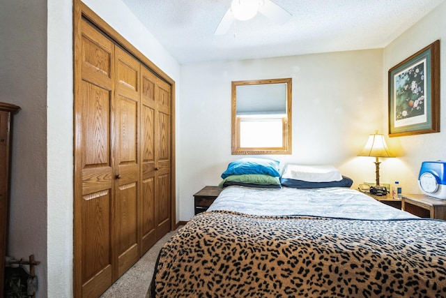 bedroom featuring carpet flooring, a ceiling fan, a closet, and a textured ceiling