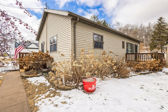 view of snowy exterior featuring a deck