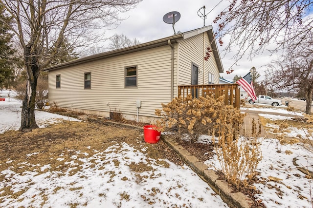 snow covered property featuring a wooden deck