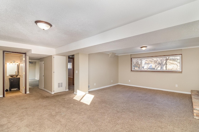 interior space featuring light carpet, visible vents, a textured ceiling, and baseboards