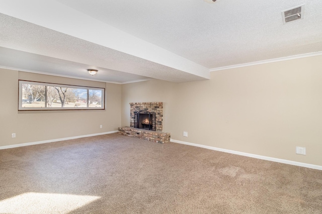 unfurnished living room with visible vents, ornamental molding, a textured ceiling, carpet flooring, and a brick fireplace