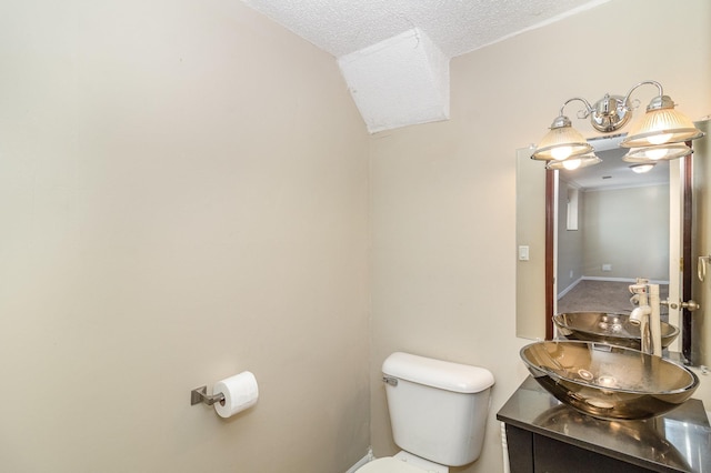 bathroom with a textured ceiling, toilet, and vanity