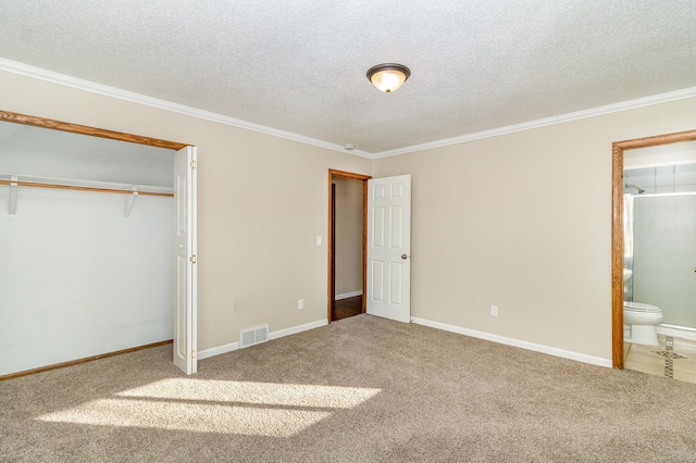 unfurnished bedroom with visible vents, crown molding, carpet, ensuite bath, and a textured ceiling