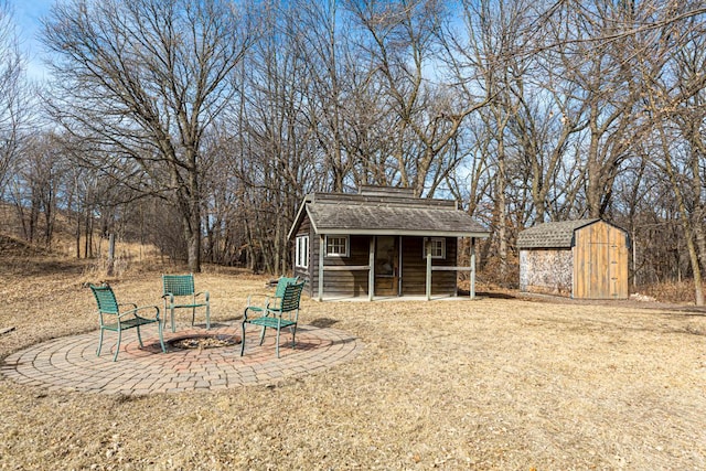 view of yard with a patio area, a fire pit, a storage shed, and an outdoor structure