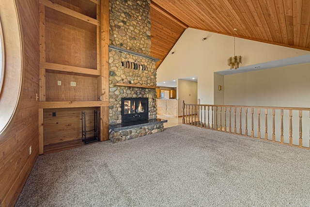 unfurnished living room featuring carpet flooring, wooden ceiling, a stone fireplace, and high vaulted ceiling