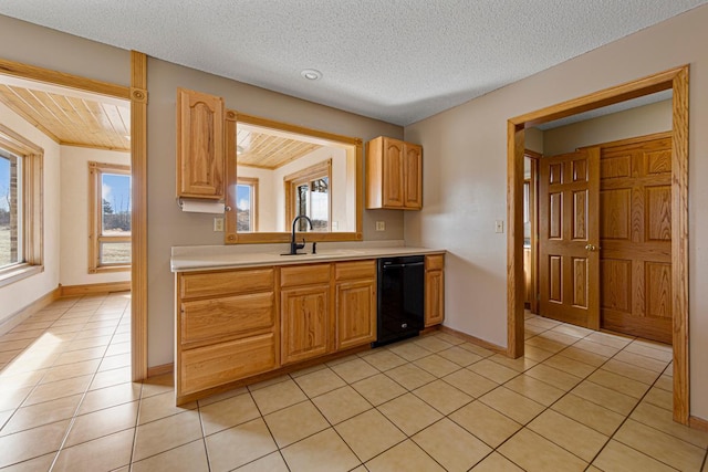 kitchen with light tile patterned floors, light countertops, black dishwasher, and a sink