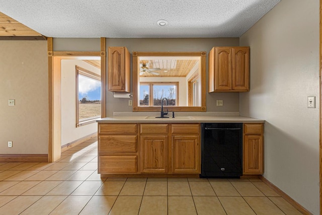 kitchen with a sink, black dishwasher, light tile patterned flooring, and light countertops