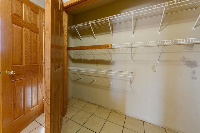 walk in closet with light tile patterned floors