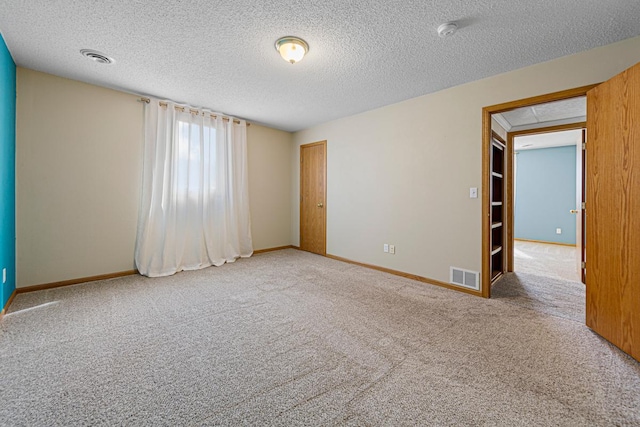 empty room with visible vents, baseboards, and carpet